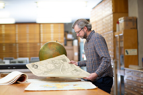 Picture of man with maps and globe